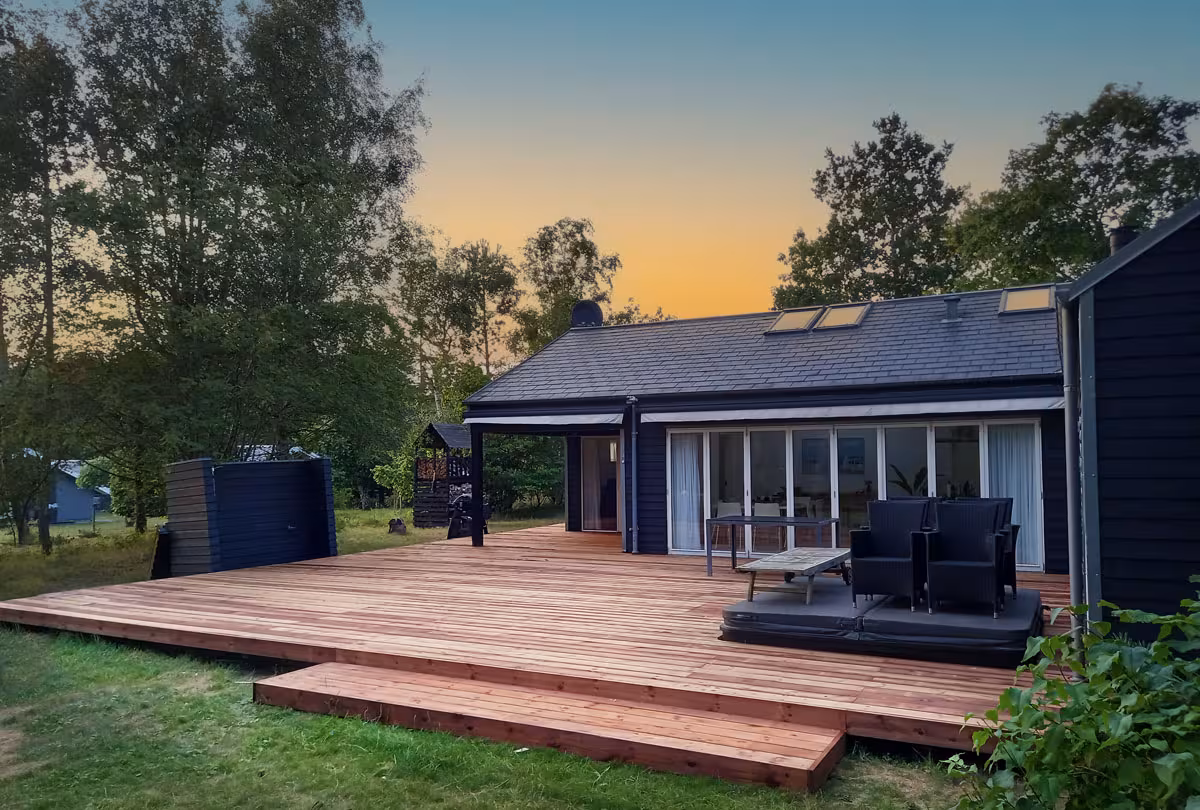 Stor træterrasse med integreret spa og gangbro om huset